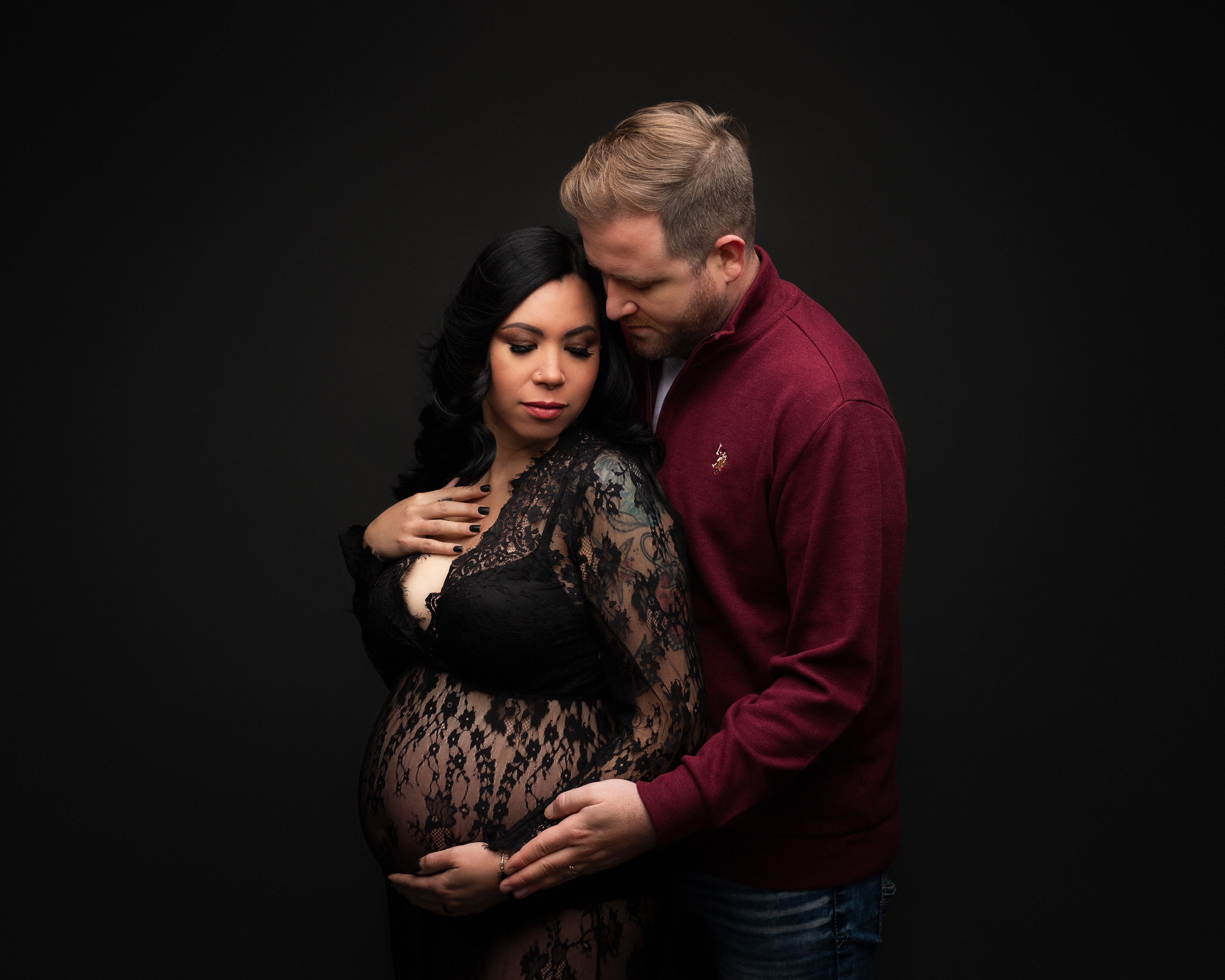 In studio maternity photography session of husband and wife.