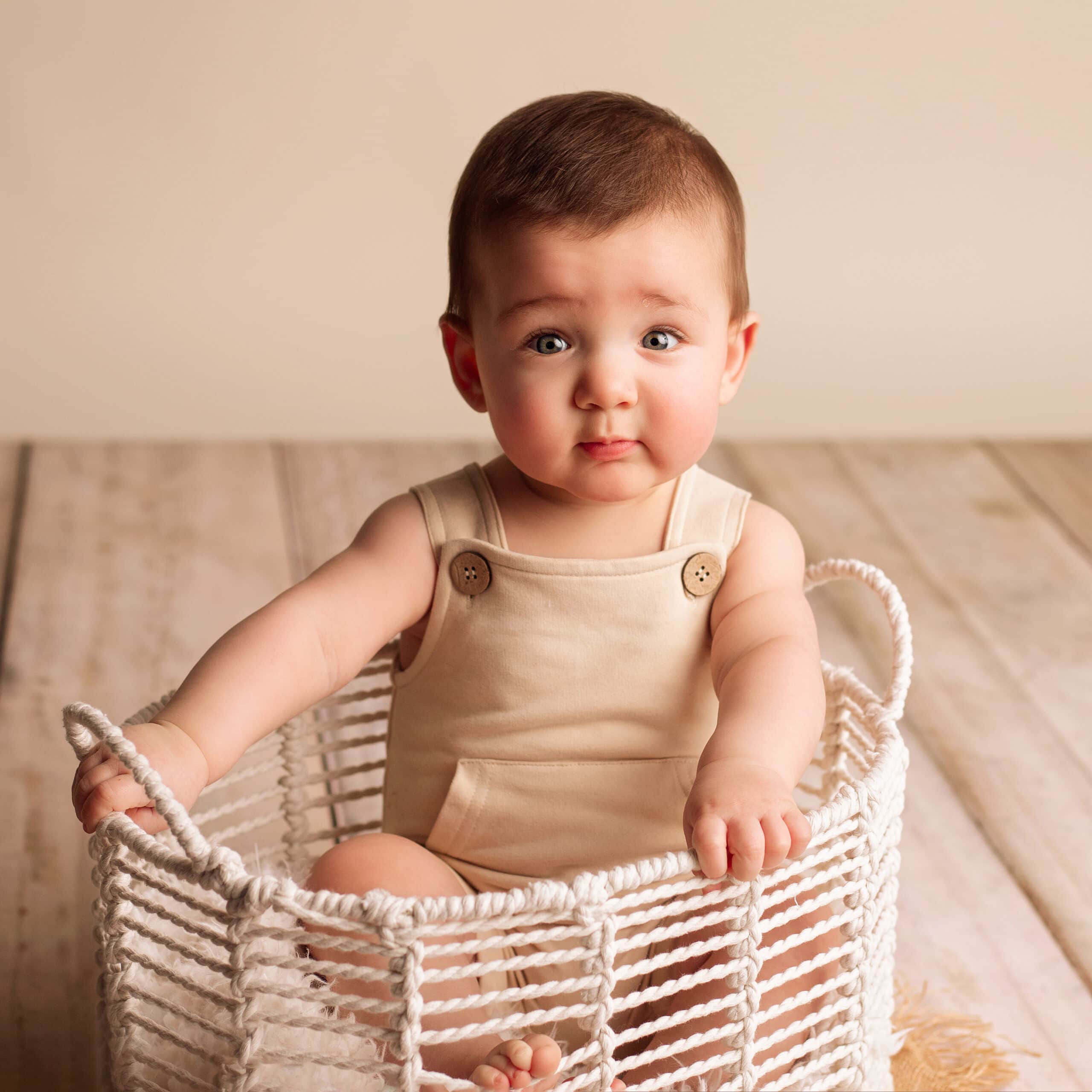 Six month boy in basket. In studio photo session in Medford, Oregon.