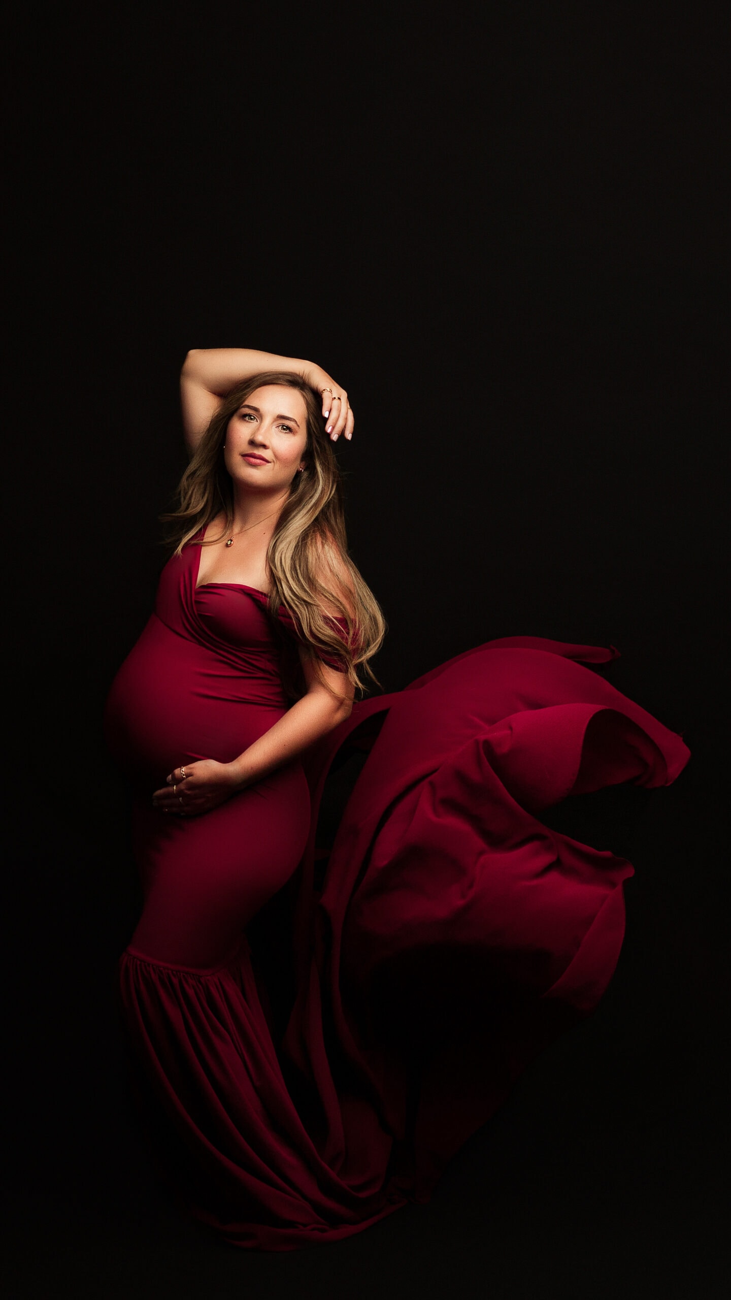 Maternity photograph in Southern Oregon wearing red dress.
